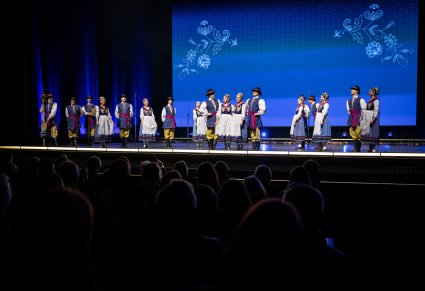 Widok na scenę na której są Artyści w kostiumach kaszubskich podczas śpiewu