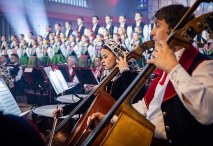 Na pierwszym planie dwójka Kontrabasistów w kostiumach wilanowskich, w tle Artyści Chóru w kostiumach łowickich
