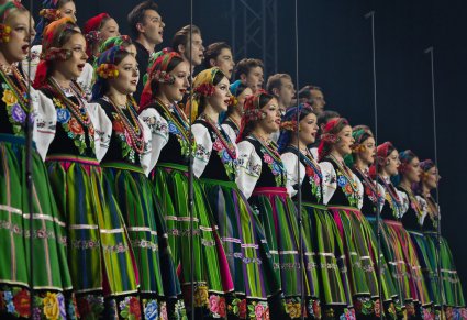 Zbliżenie na Artystów Chóru w kostiumach łowickich w trakcie śpiewu