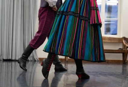 Zbliżenie na układ stóp podczas warsztatów tanecznych, widoczne elementy kostiumu opoczyńskiego