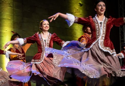 Zbliżenie na Artystów w kontuszach na scenie w trakcie wykonywania choreografii tanecznej