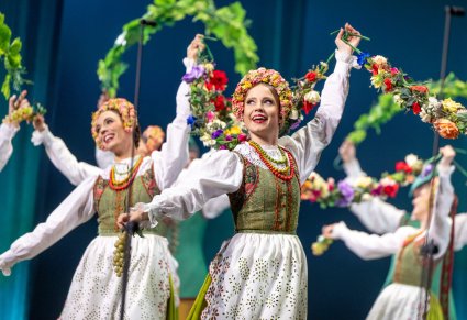 Zbliżenie na Artystki w kostiumach lubuskich podczas wykonywania choreografii tanecznej z wykorzystaniem elementów które przypominają winorośle