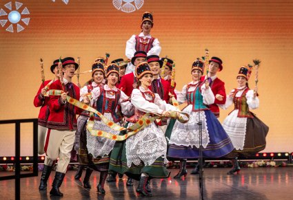 Grupa Artystów w kostiumach kurpiowskich w trakcie wykonywania imponującej choreografii tanecznej