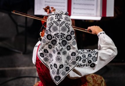 Widok z góry na Artystkę Orkiestry w kostiumie wilanowskim, grającą na instrumencie smyczkowym