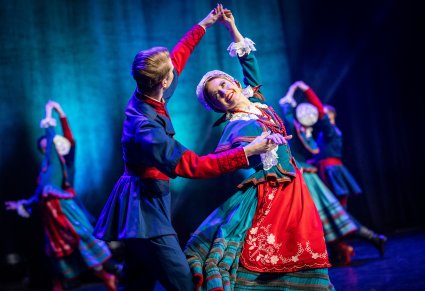 Para taneczna w kostiumie kujawskim w figurze tanecznej na scenie