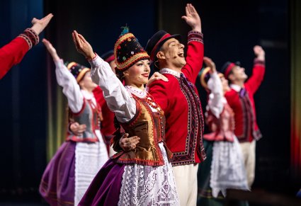 Zbliżenie na pary Artystów w kostiumach kurpiowskich (Kurpie Puszczy Zielonej) w trakcie wykonywania choreografii tanecznej