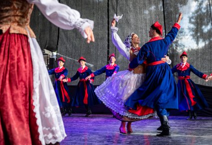 Para Artystów na pierwszym planie w kostiumach wilanowskich w trakcie wykonywania choreografii tanecznej