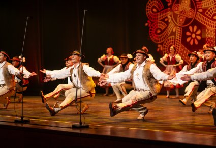 Tancerze w kostiumach jurgowskich podczas akrobacji tanecznych na scenie