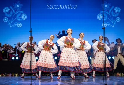 Na środku sceny Artystki Baletu  w kostiumach szczawnickich w trakcie wykonywania choreografii tanecznej
