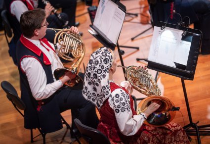 Zbliżenie na dwóch Muzyków w kostiumach wilanowskich grających na waltorni