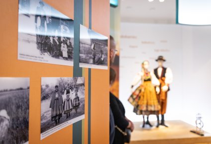 Elementy wystawy w Centrum Folkloru Polskiego, w tle damski i męski kostium łowicki