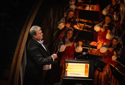 Zbliżenie na Dyrektora zespołu w trakcie dyrygowania orkiestrze