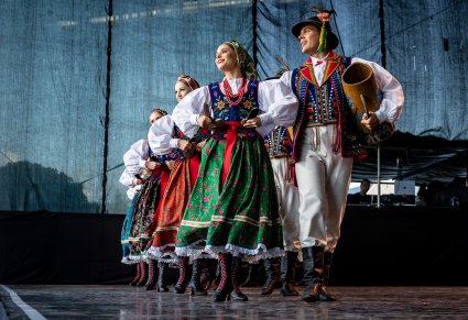 Artyści w parach na scenie w kostiumach limanowskich w czasie wykonywania choreografii tanecznej