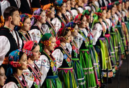 Zbliżenie na Artystów Chóru w kostiumach łowickich w trakcie śpiewu