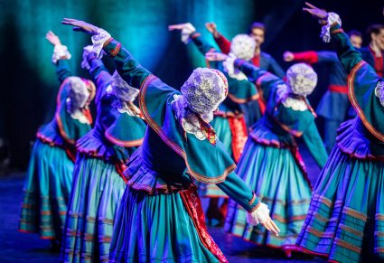 Tancerki w kostiumach kujawskich na scenie w pozycjach tanecznych