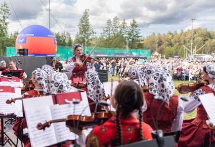 Koncertmistrzyni zwrócona w stronę Artystów Orkiestry ubranych w kostiumy wilanowskie