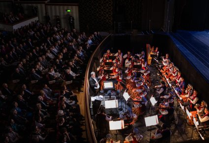 Widok na orkiestrę z góry, widoczna również część publiczności