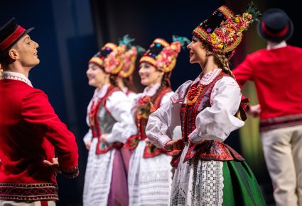 Zbliżenie na Artystów w kostiumach kurpiowskich (Kurpie Puszczy Zielonej) w trakcie wykonywania choreografii tanecznej