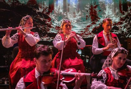 Zbliżenie na muzyków, w kostiumach wilanowskich, grających na instrumentach dętych i smyczkowych
