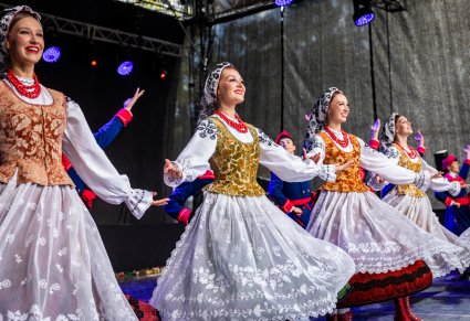 Uśmiechnięci Artyści w kostiumach wilanowskich na scenie podczas wykonywania choreografii tanecznej