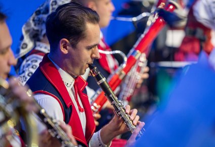 Zbliżenie na Artystów Orkiestry w kostiumach wilanowskich podczas grania na instrumentach dętych