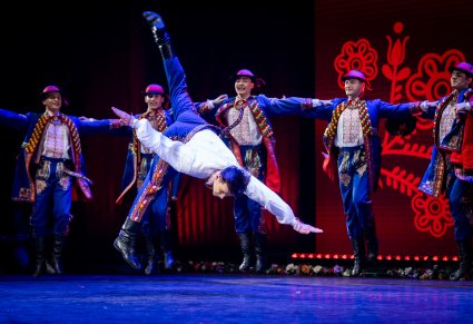 Tancerz w kostiumie podegrodzkim na scenie w tanecznej pozie