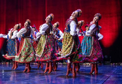 Tancerki w kostiumach krakowskich w figurze tanecznej na scenie