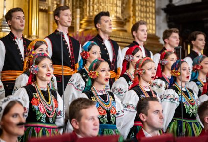 Zbliżenie na Artystów Chóru w kostiumach łowickich, i część Artystów Orkiestry w kostiumach wilanowskich