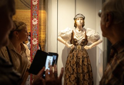 Goście Narodowego Czytania, podziwiający kostium cieszyński, podczas zwiedzania Centrum Folkloru Polskiego "Karolin"