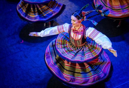 Widok na kręcącą się Artystkę w kostiumie krzczonowskim na scenie