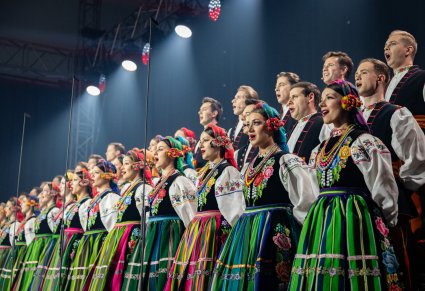 Zbliżenie na Artystów Chóru w kostiumach łowickich w trakcie śpiewu