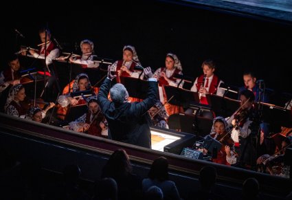 Dyrektor zespołu dyrygujący orkiestrze w kostiumach wilanowskich