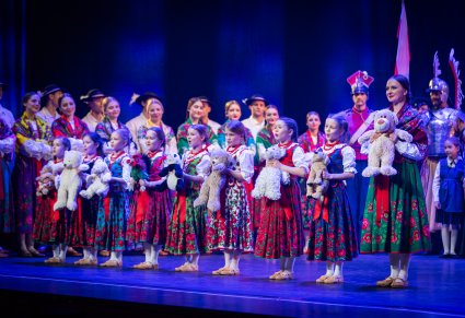 Przedszkolaki w kostiumach ludowych trzymające w ręku pluszowe maskotki