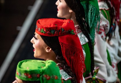 Zbliżenie na artystki chóru w kostiumach kurpiowskich na scenie podczas wykonywania utworu