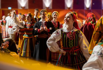 Grupa Artystów w kostiumach ludowych wchodząca na scenę