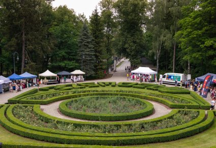 Widok na wystawców i partnerów Pikniku Rodzinnego, z krzewów stworzony jest napis MAZOWSZE