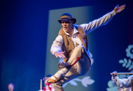 Tancerz w kostiumie jurgowskim w figurze tanecznej na scenie