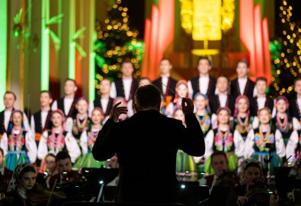 Na pierwszym planie Dyrygent zwrócony w stronę Artystów Chóru