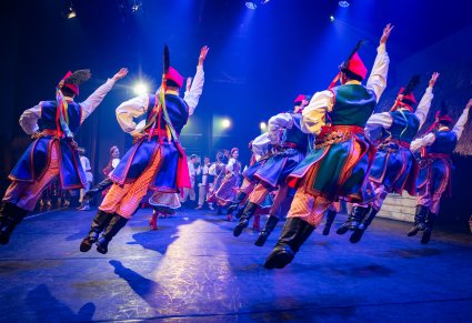 Artyści w kostiumach krakowskich w trakcie wykonywania choreografii tanecznej