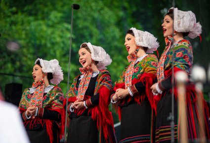 Cztery artystki w kostiumach wielkopolskich śpiewają na scenie