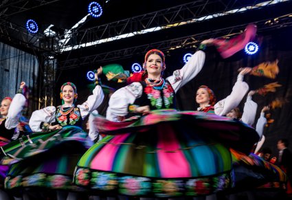 Koncert Zespołu Mazowsze - Artystki w kostiumach łowickich uchwycone w wirującym tańcu