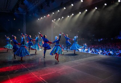 Artyści baletu w kostiumach kujawskich tańczą na scenie