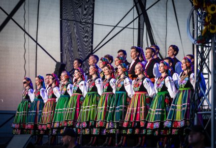 Chór w kostiumach łowickich śpiewa na scenie