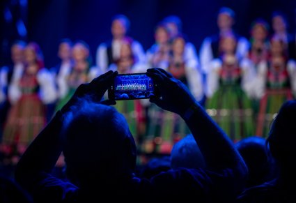 Zbliżenie na telefon jednego z widzów, który nagrywa koncert