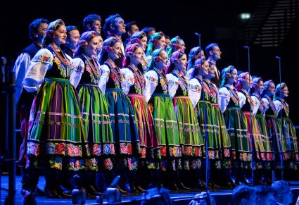 Chór w kostiumach łowickich śpiewa na scenie