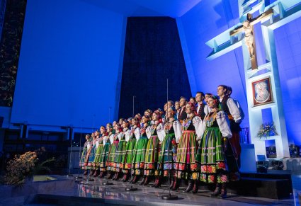 Chór w kostiumach łowickich śpiewa przed ołtarzem