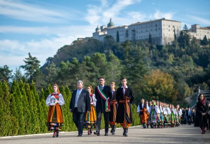 Przedstawiciele i chór Mazowsza idzie drogą prowadzącą na cmentarz na Monte Cassino