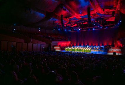 Artyści w kostiumach kurpiowskich śpiewają na scenie