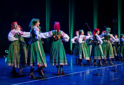 Na scenie śpiewające Artystki w kostiumach kurpiowskich podczas wykonywania choreografii