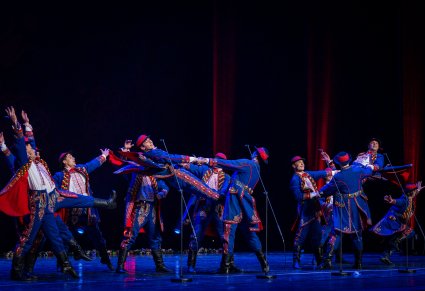 Artyści w kostiumach podegrodzkich podczas wykonywania figur tanecznych na scenie